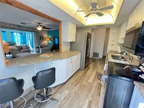 a kitchen with stainless steel appliances granite countertop a sink refrigerator and microwave