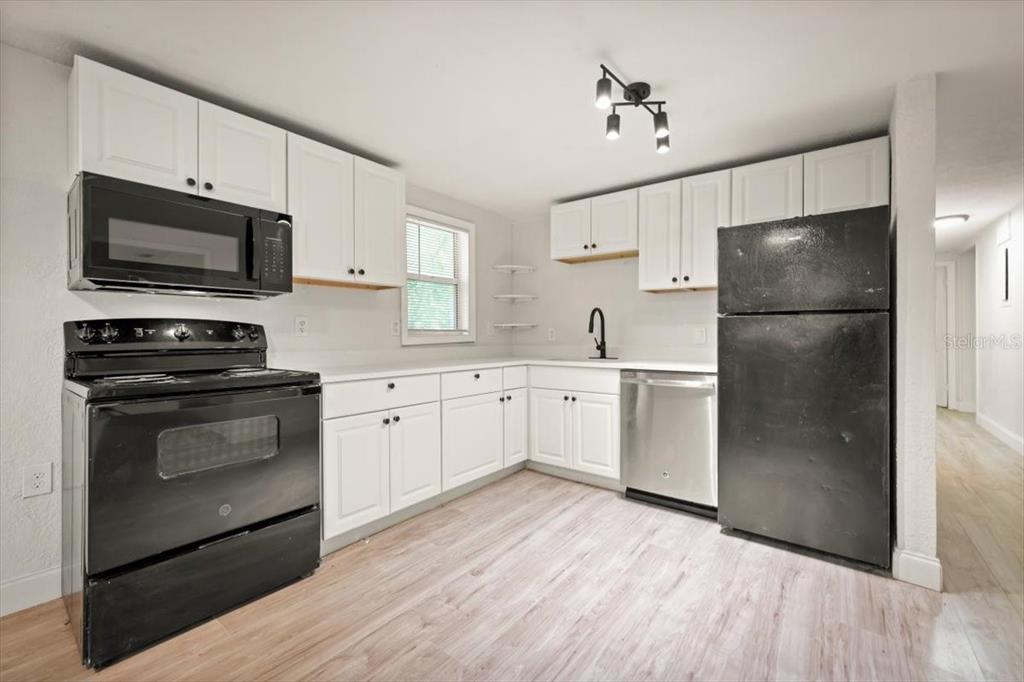 7903 New Kings Road Jacksonville, FL 32219 - Photo 11 of 28 a kitchen with a refrigerator stove and white cabinets