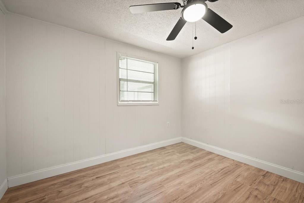 7903 New Kings Road Jacksonville, FL 32219 - Photo 18 of 28 an empty room with wooden floor chandelier fan and windows