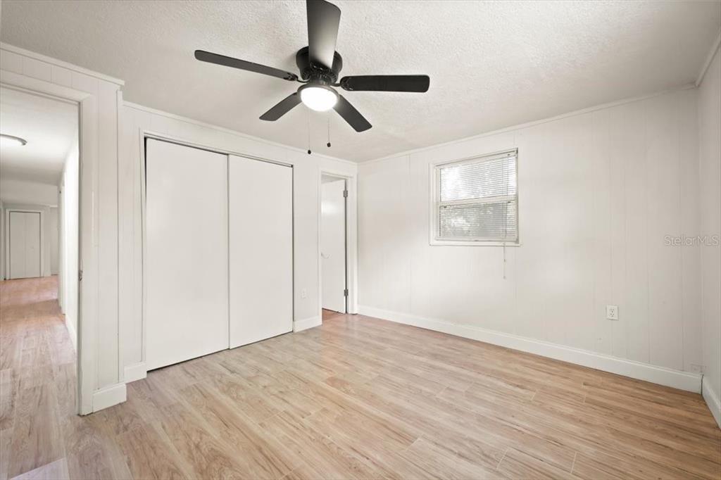 7903 New Kings Road Jacksonville, FL 32219 - Photo 23 of 28 an empty room with wooden floor ceiling fan and windows