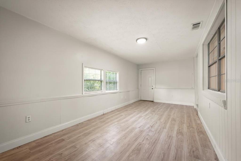 7903 New Kings Road Jacksonville, FL 32219 - Photo 3 of 28 wooden floor in an empty room with a window