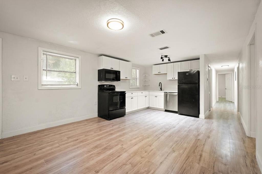 7903 New Kings Road Jacksonville, FL 32219 - Photo 9 of 28 a large kitchen with cabinets stainless steel appliances and wooden floor