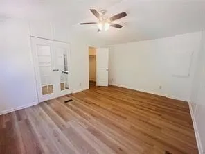 a view of a livingroom with wooden floor and a ceiling fan