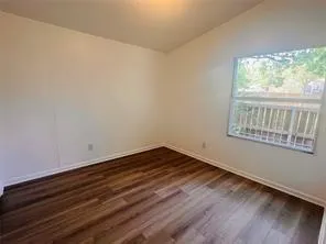an empty room with wooden floor and closet