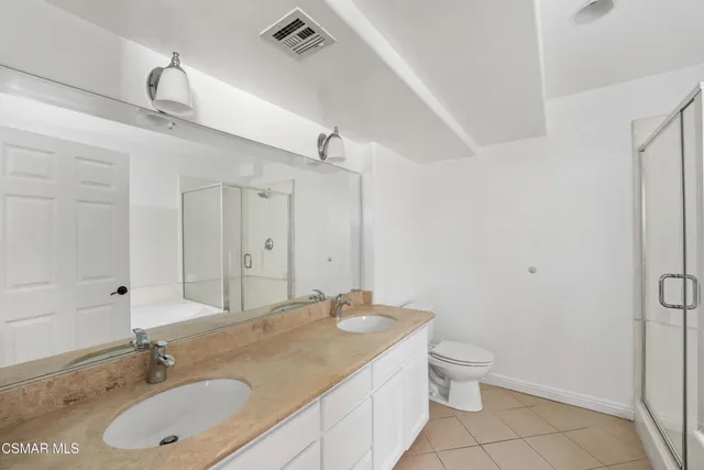 a bathroom with a granite countertop sink a toilet and a mirror