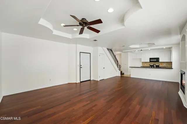 a view of empty room with wooden floor and window