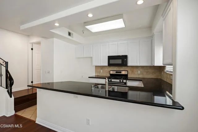 a kitchen with stainless steel appliances granite countertop a stove and a sink