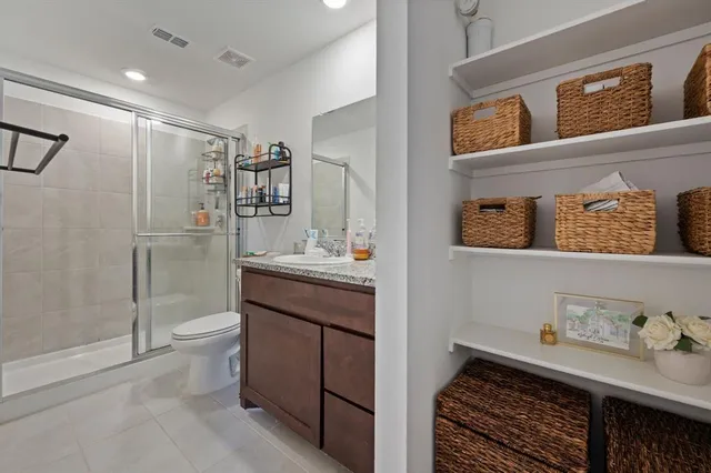 a bathroom with a granite countertop sink a toilet and shower
