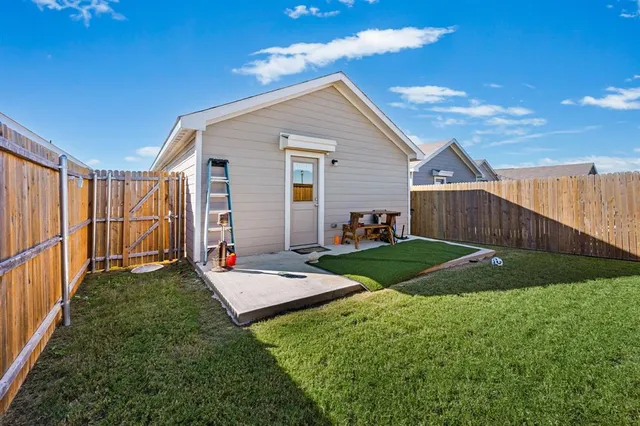 a view of a backyard with wooden fence