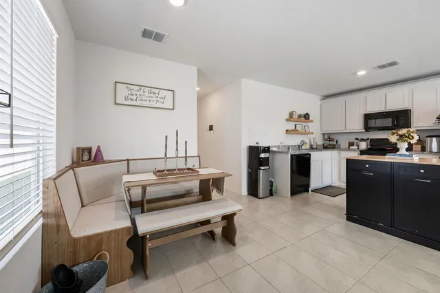 a living room with stainless steel appliances furniture and a window