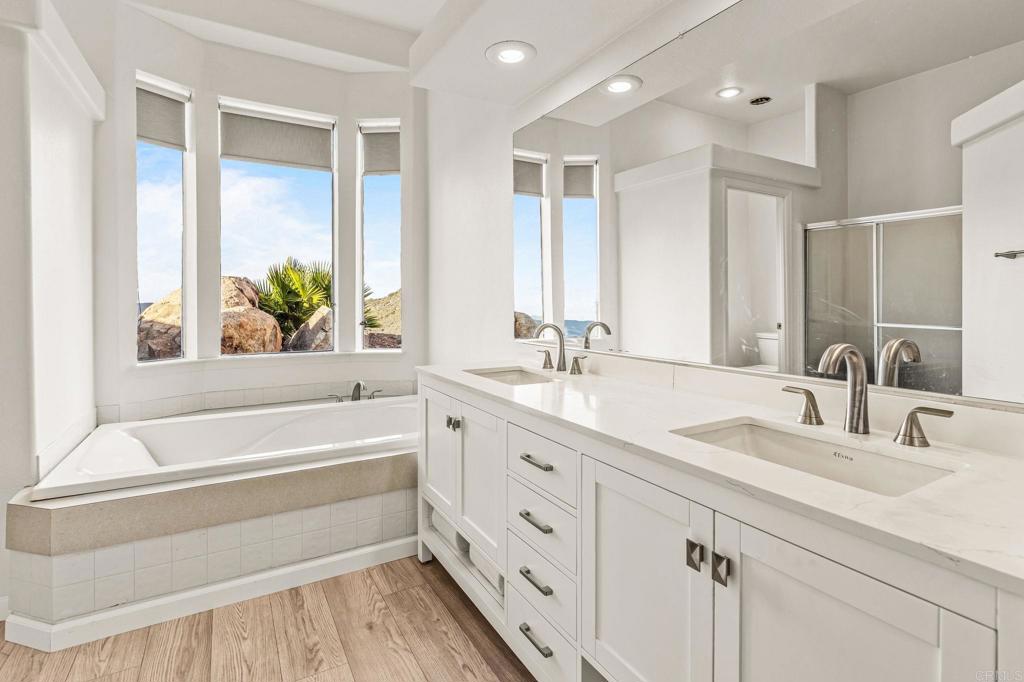 15351 Isla Vista Road Jamul, CA 91935 - Photo 16 of 40 a bathroom with a tub a sink and a large mirror
