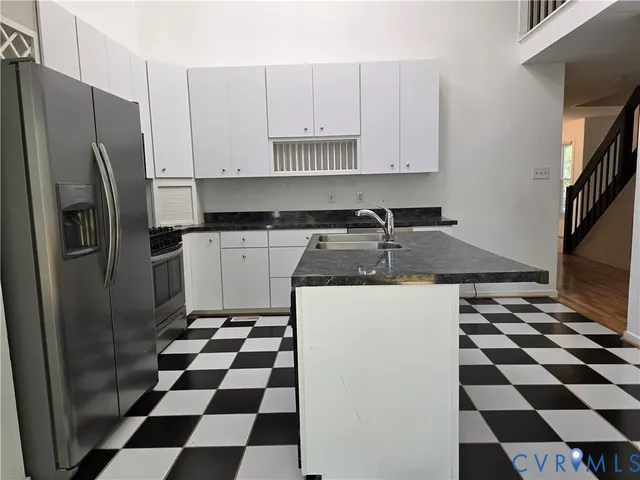 a kitchen with a checkered floor and white cabinets