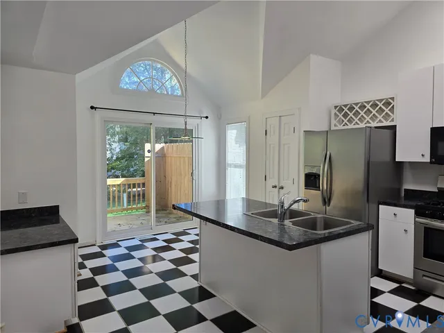 a kitchen with a sink a refrigerator and a stove top oven