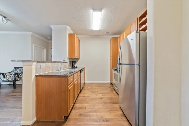 a kitchen with granite countertop cabinets stainless steel appliances and a window