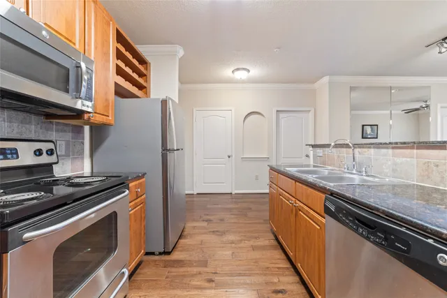 a kitchen with stainless steel appliances a refrigerator and a stove top oven