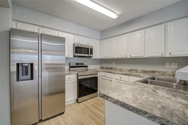a kitchen with a refrigerator stove and microwave