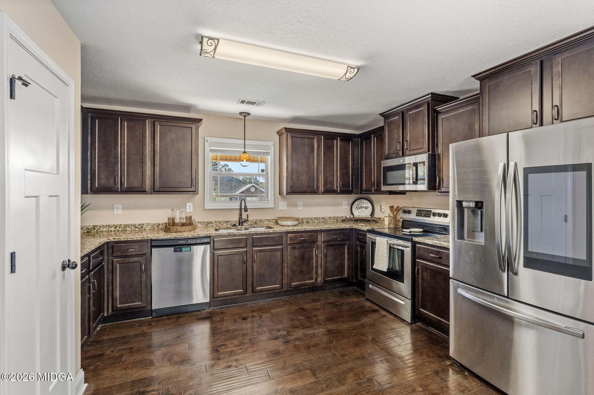 109 Hawks Rdg Trace Byron, GA 31008 - Photo 8 of 26 a kitchen with granite countertop stainless steel appliances and wooden cabinets
