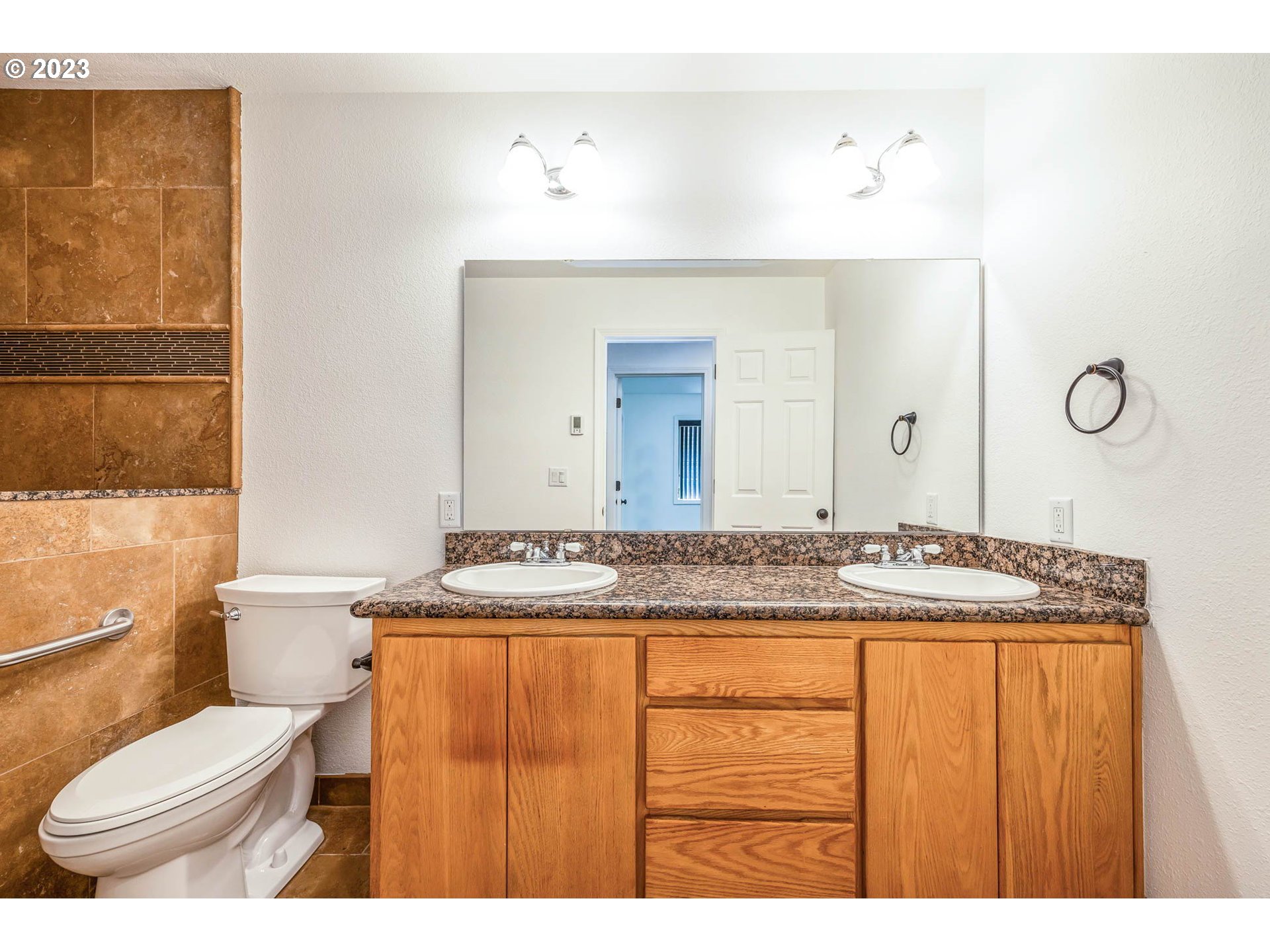 789 South 69th Street Springfield, OR 97478 - Photo 18 of 46 a bathroom with a granite countertop sink a toilet and a mirror