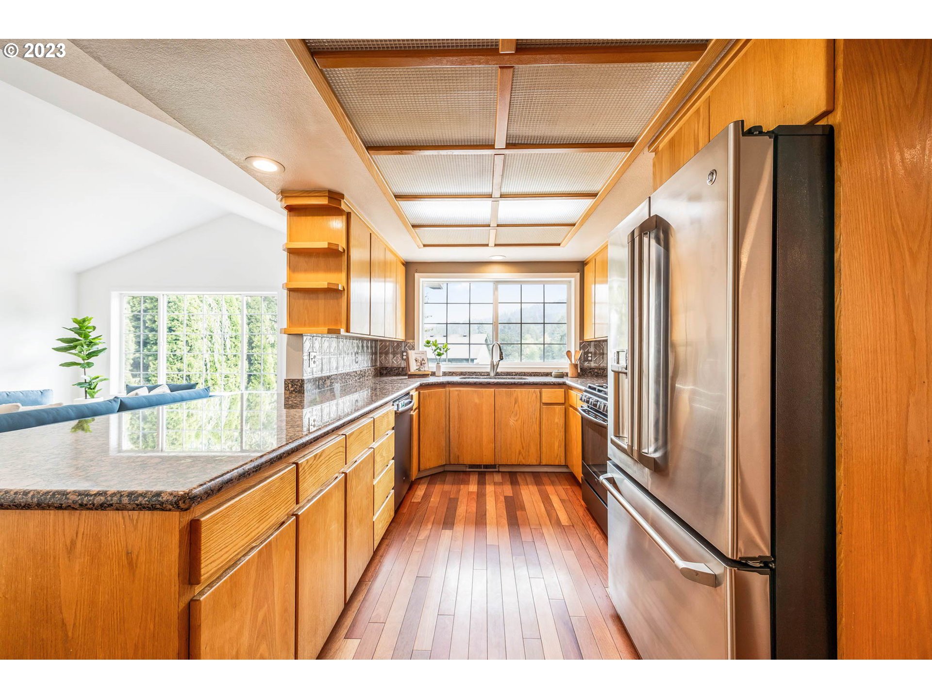 789 South 69th Street Springfield, OR 97478 - Photo 25 of 46 a kitchen with stainless steel appliances granite countertop a refrigerator a sink and a dishwasher with wooden floor