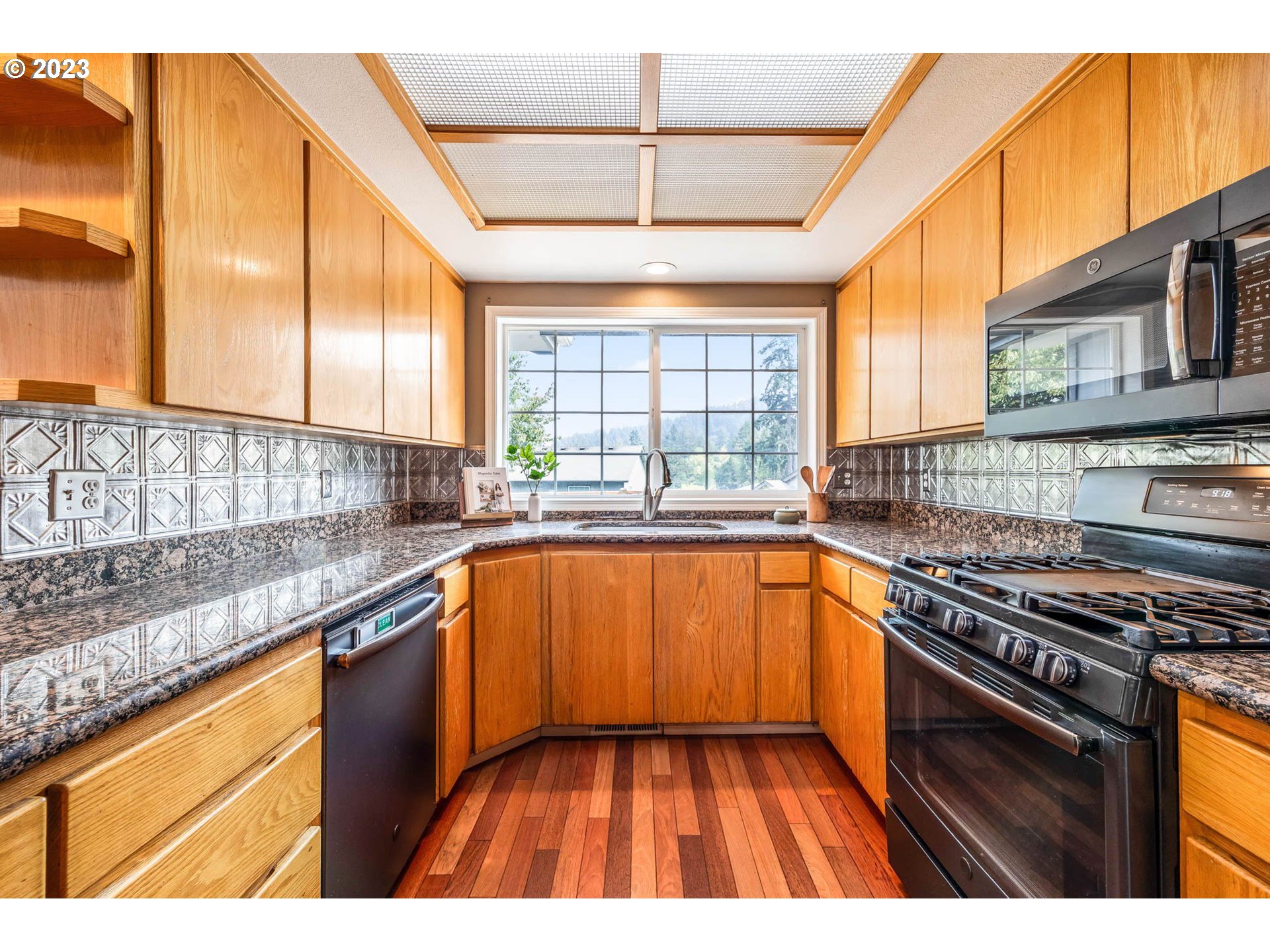 789 South 69th Street Springfield, OR 97478 - Photo 26 of 46 a kitchen with stainless steel appliances granite countertop a stove a sink and a microwave