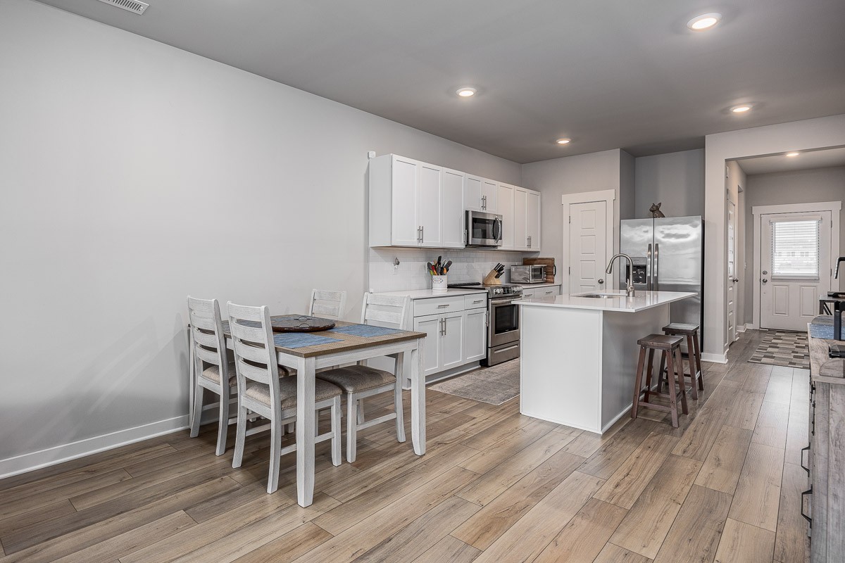 717 Mickelson Way Lebanon, TN 37087 - Photo 6 of 28 a kitchen with a table chairs a sink dishwasher stove and cabinets with wooden floor