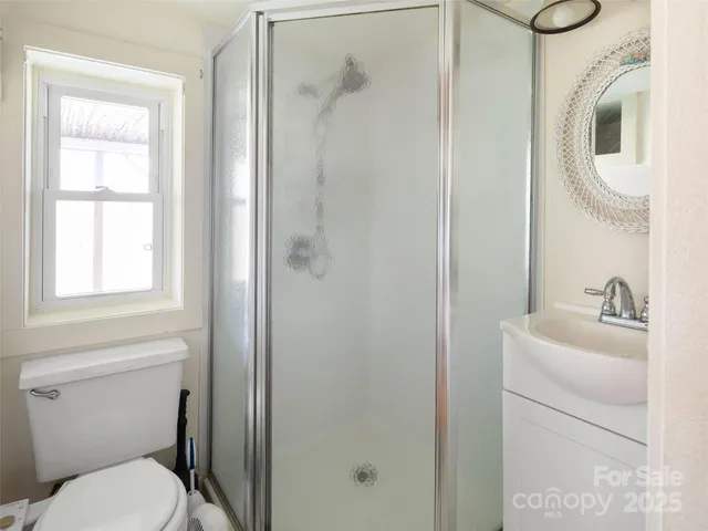 a bathroom with a toilet sink vanity and mirror