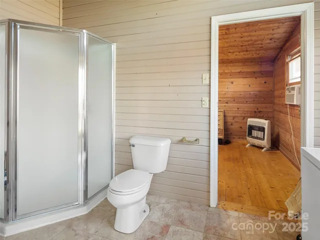 a bathroom with a toilet and a shower