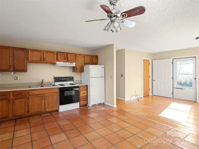 a kitchen with stainless steel appliances granite countertop a refrigerator and a sink
