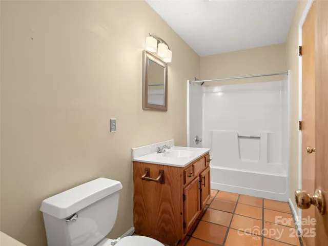 a bathroom with a sink a toilet a mirror and shower