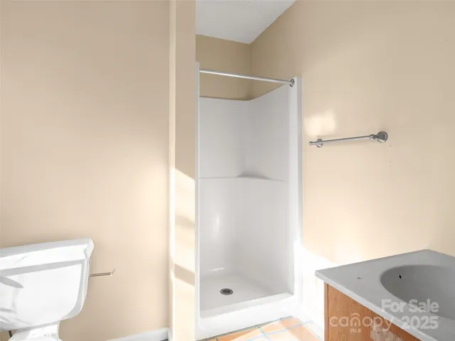 a bathroom with a granite countertop bathtub shower sink and toilet