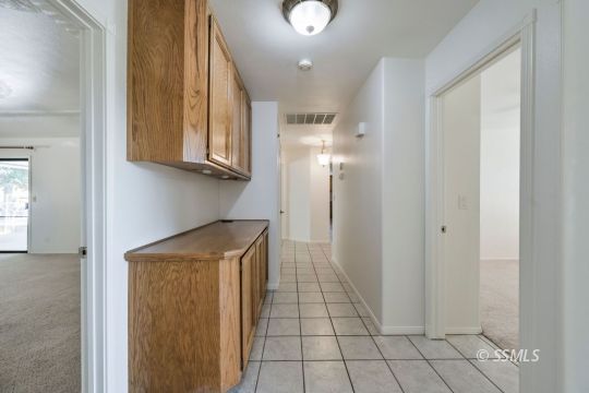 1257 Carolyn Street Ridgecrest, CA 93555 - Photo 21 of 42 a kitchen with white cabinets and a refrigerator