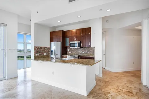 a kitchen with stainless steel appliances granite countertop a sink a stove and a wooden floors