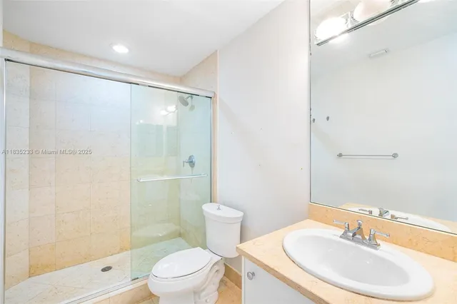 an aerial view of a city with lots of residential buildings ocean and mountain view in back