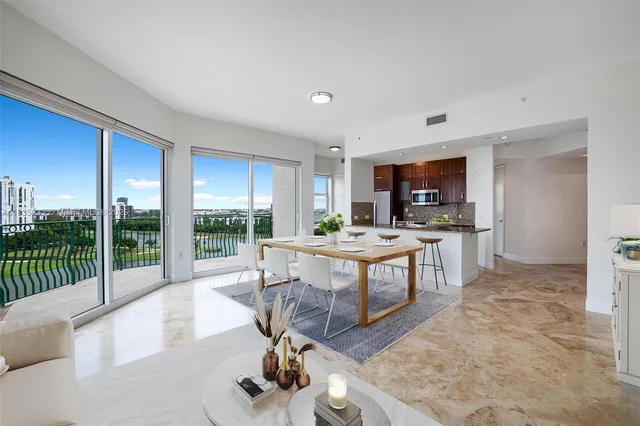 a living room with furniture a flat screen tv and a floor to ceiling window