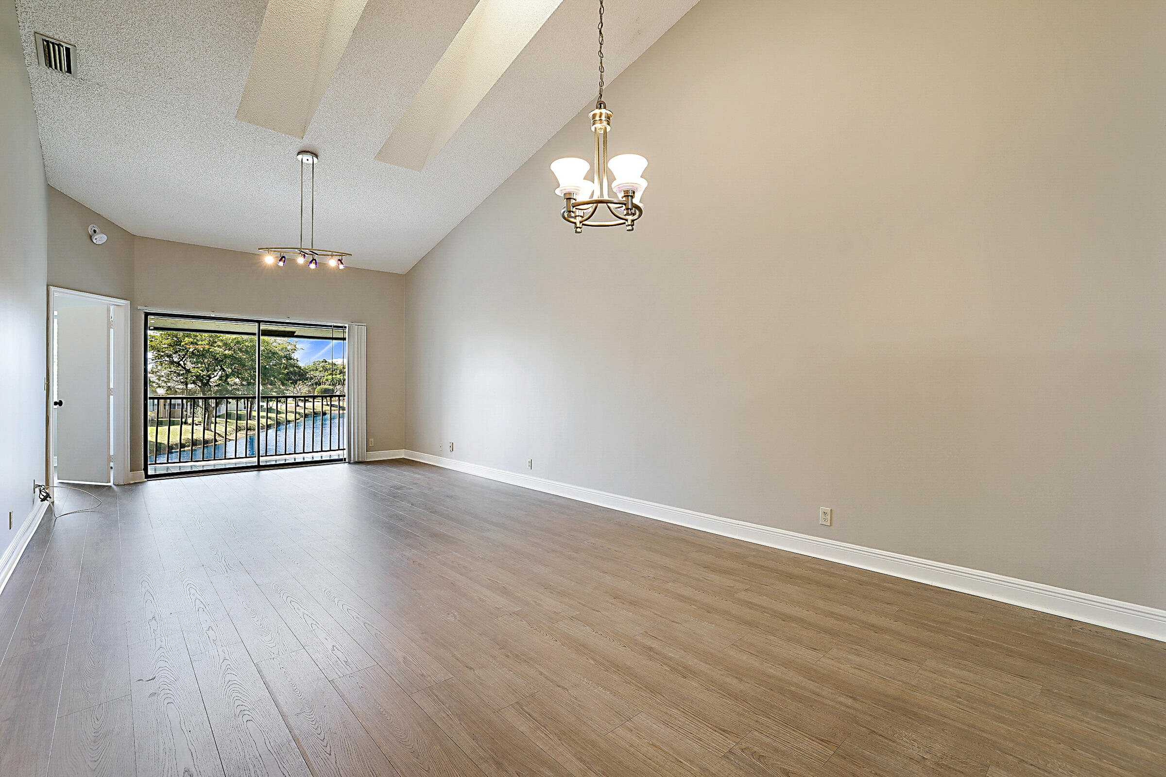 605 Harbour Pointe Way Greenacres, FL 33413 - Photo 13 of 48 an empty room with wooden floor and windows