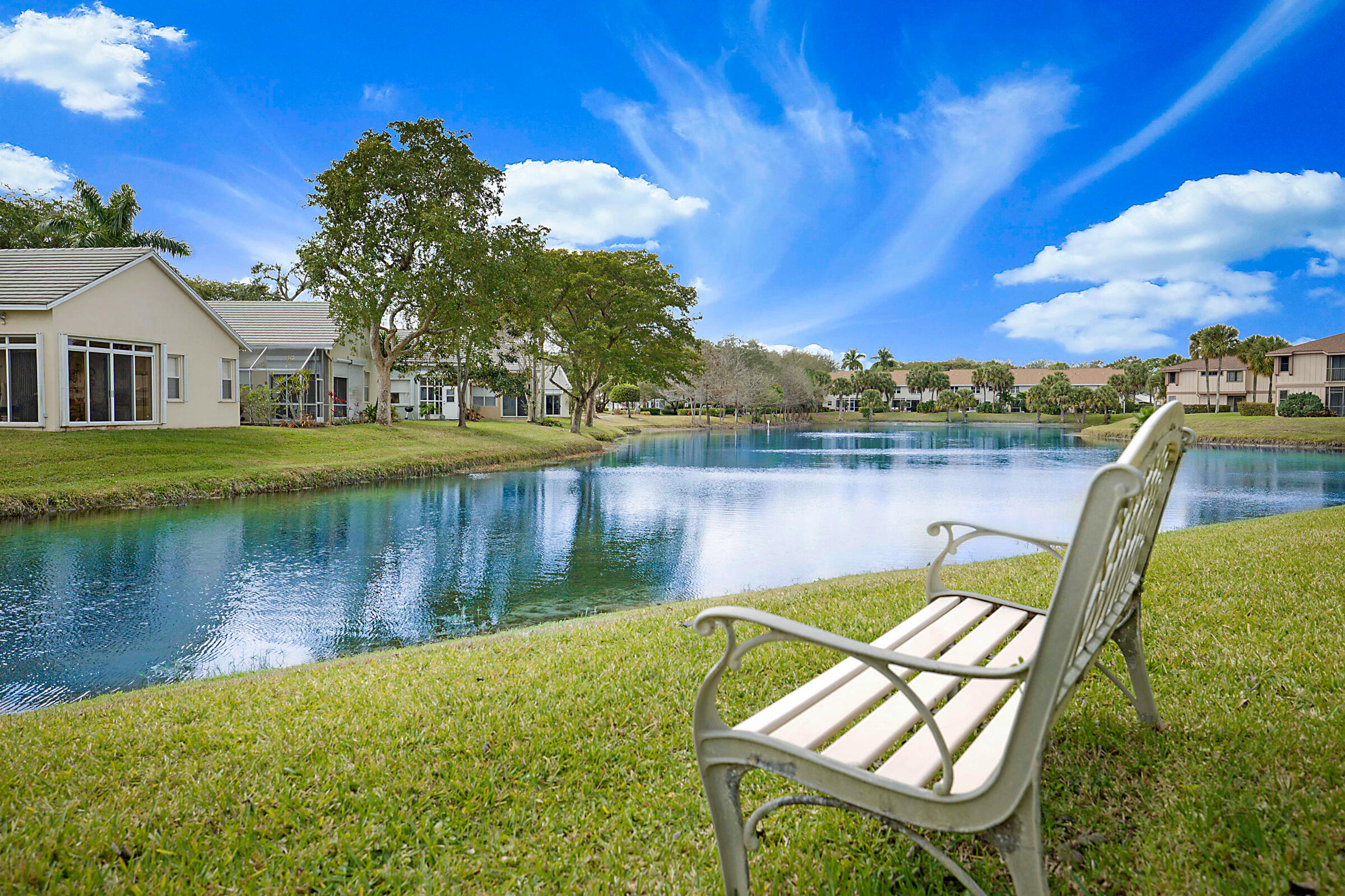 605 Harbour Pointe Way Greenacres, FL 33413 - Photo 37 of 48 a view of a lake with a house in the background