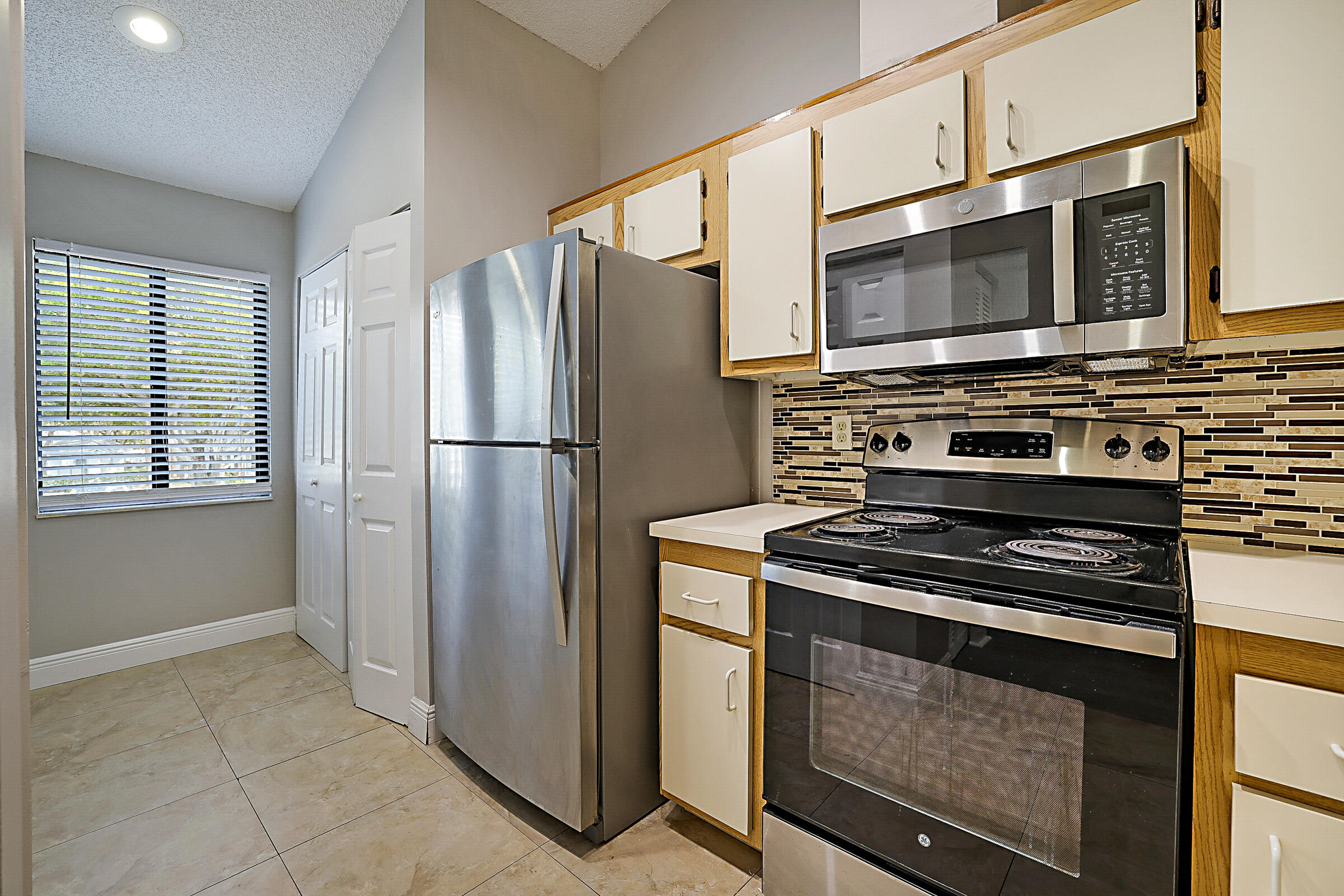605 Harbour Pointe Way Greenacres, FL 33413 - Photo 6 of 48 a kitchen with stainless steel appliances a refrigerator stove and microwave