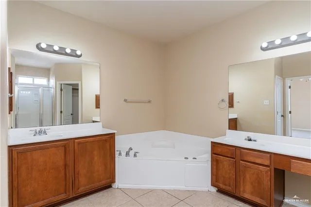 a spacious bathroom with a tub sink and mirror