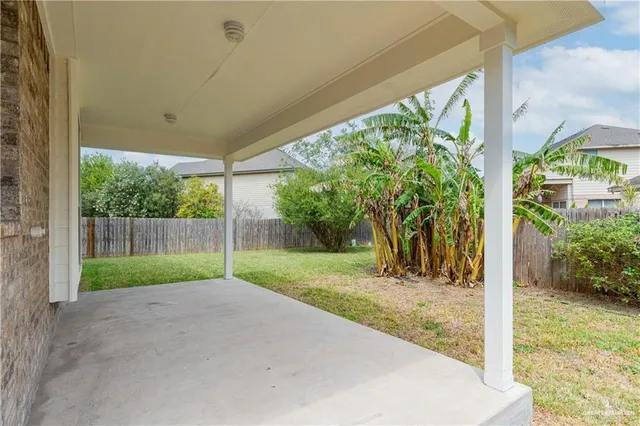 a view of a white house with a large window and a yard