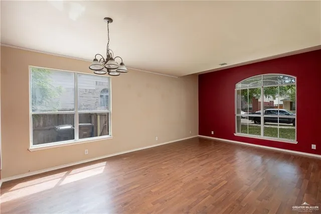 a view of a room with window wooden floor and front door