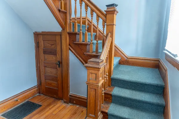 a view of front door with wooden floor and stairs