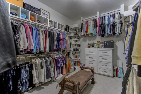 a view of walk in closet with clothes and shoes