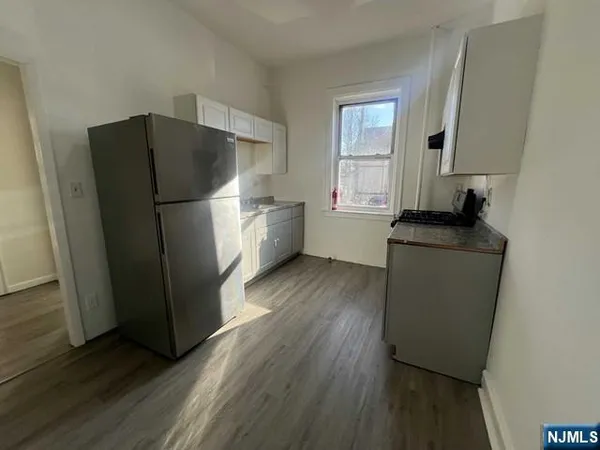 a kitchen with a refrigerator sink and wooden floor