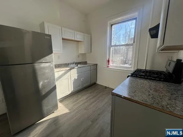 a kitchen with granite countertop a refrigerator stove and sink