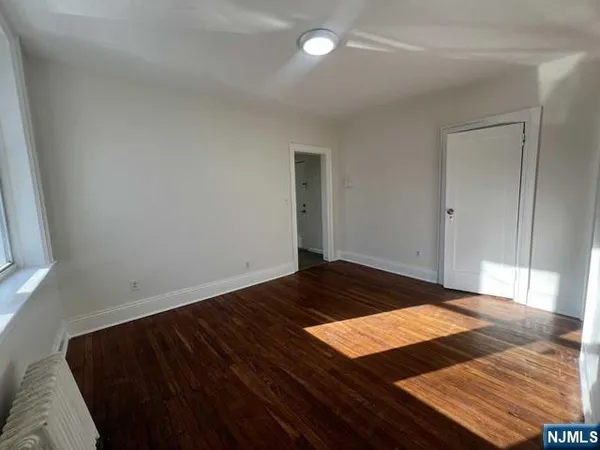 a view of a room with wooden floor and bedroom