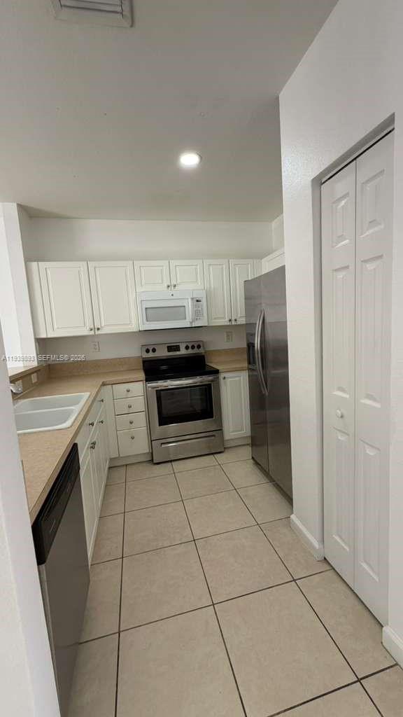 1555 Northeast 33rd Road, Unit 1012 Homestead, FL 33033 - Photo 11 of 54 a kitchen with stainless steel appliances granite countertop a refrigerator sink and cabinets