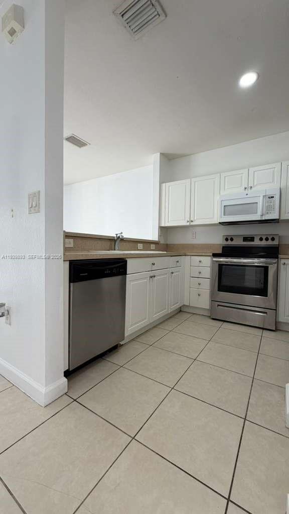 1555 Northeast 33rd Road, Unit 1012 Homestead, FL 33033 - Photo 13 of 54 a kitchen with stainless steel appliances granite countertop a stove a sink and a microwave