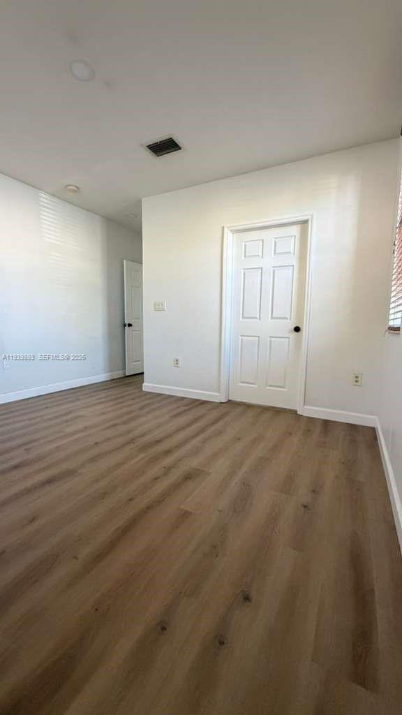 1555 Northeast 33rd Road, Unit 1012 Homestead, FL 33033 - Photo 22 of 54 an empty room with wooden floor and windows