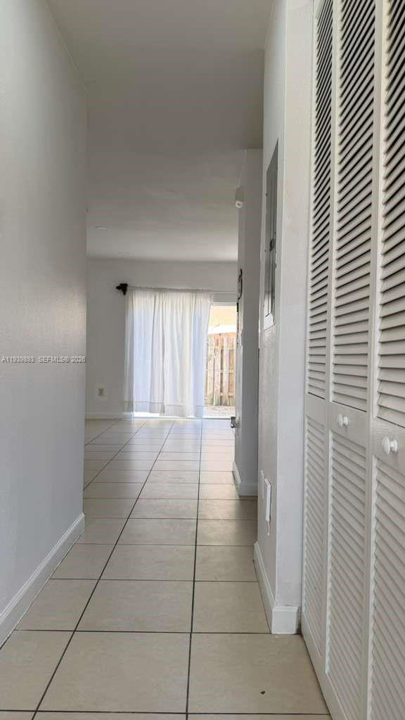 1555 Northeast 33rd Road, Unit 1012 Homestead, FL 33033 - Photo 25 of 54 a hallway with a window and a kitchen