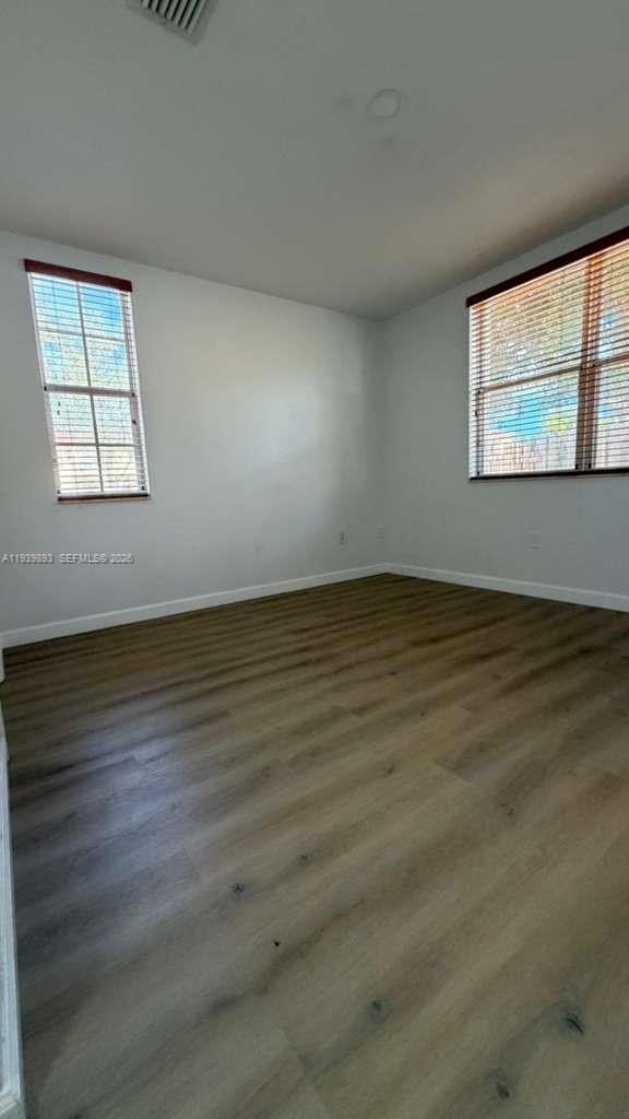 1555 Northeast 33rd Road, Unit 1012 Homestead, FL 33033 - Photo 28 of 54 an empty room with wooden floor and windows